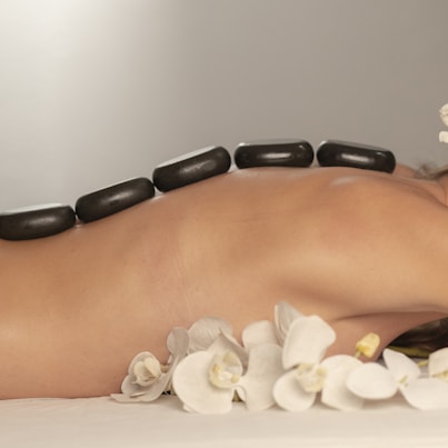 Hot stone massage treatment with smooth heated stones placed on the back
